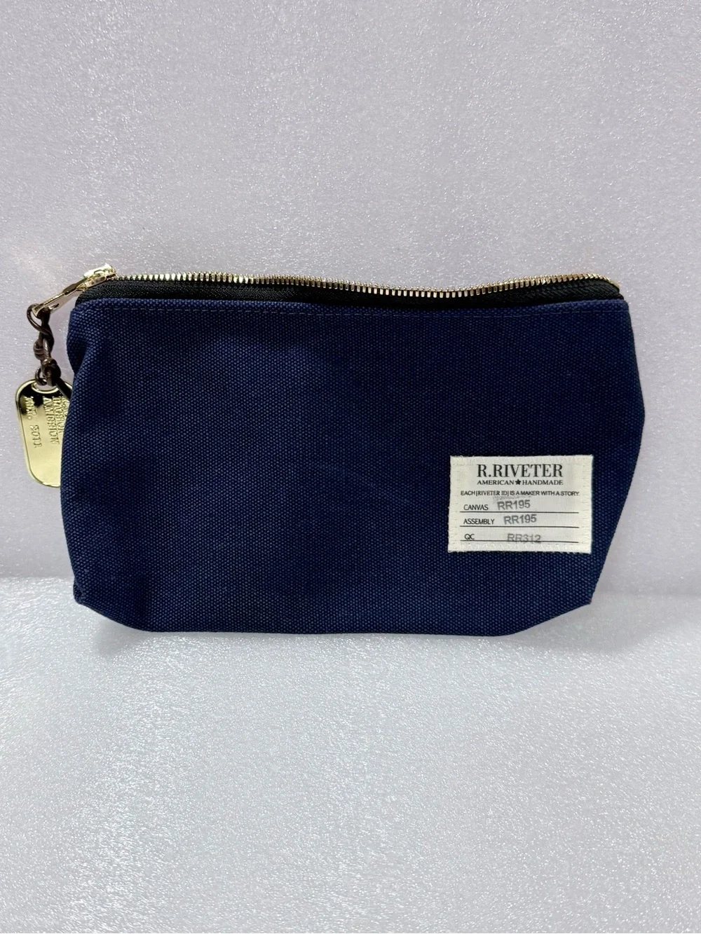 R.Riveter Lucy Canvas Zipper Pouch features a gold-toned dog tag accessory